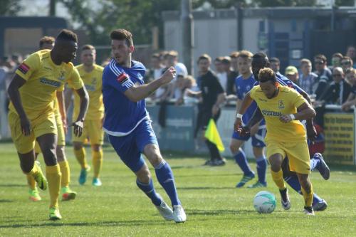 Billericays Joe Ellul (blue) checks where his colleagues are as Tyler Campbell runs at the defence