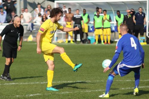 Enfields Harry Ottaway (yellow) chips the ball into the penalty area
