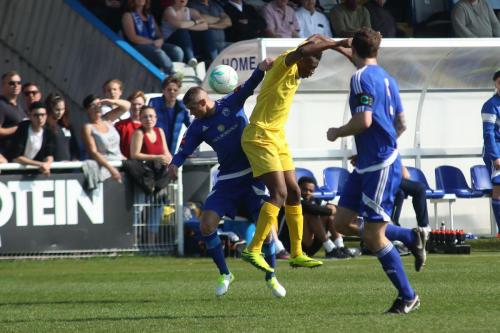 Enfields Karl Oliyide (yellow) challenges Paul Konchesky