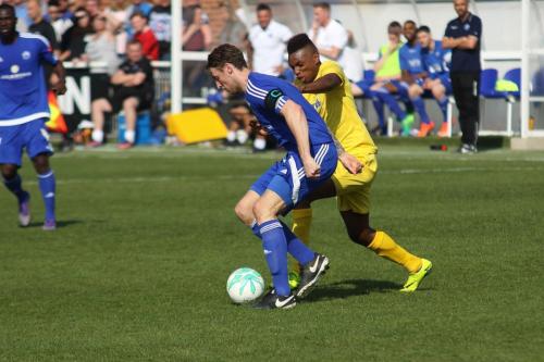 Enfields Karl Oliyide (yellow) challenges Rob Swaine