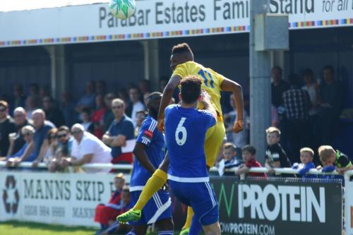 Enfields Karl Oliyide (yellow) wins the ball ahead of Joe Ellul (6) and Tambeson Eyong