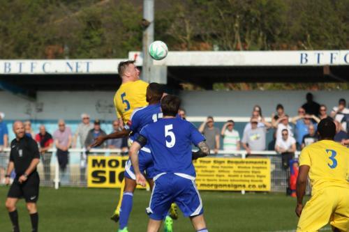 Enfields Mark Kirby (yellow) heads the ball on
