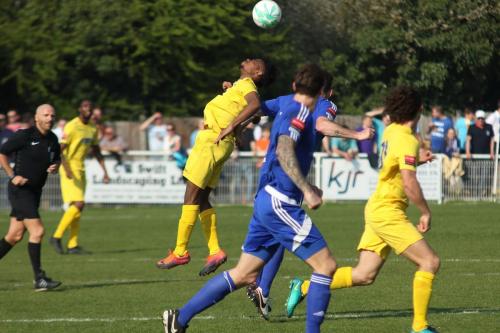 Enields Dernell Wynter (yellow, L) flicks the ball on