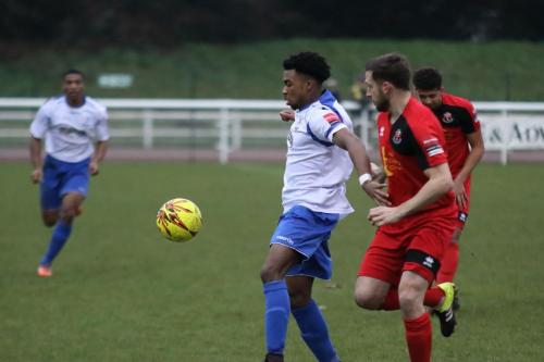Enfields Dernell Wynter holds off Adam Tann (red)