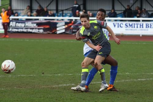 Havants Wes Fogden (grey) clears from Bobby Devyne