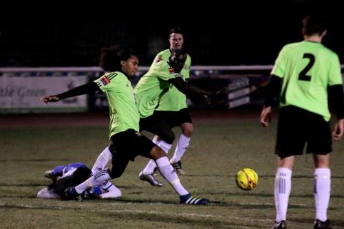 Hendons Kezie Ibe (green, L) clears
