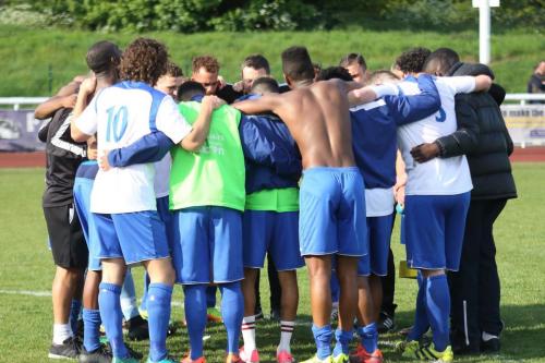 Enfield players join in a post-match huddle