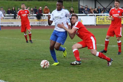 Enfields Karl Oliyide breaks through the challenge of Joe Jefford (red)