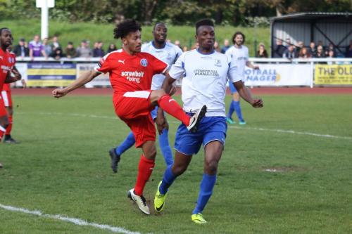 Leistons Ollie Brown (red) clears from Karl Oliyide