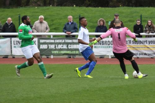 Leatherhead keeper Louis Wells clears from Karl Oliyide as Jerry Nnamani (L) looks on