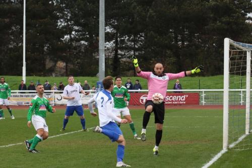 Leatherhead keeper Louis Wells watches alooping  cross from the far side drop wide of the goal