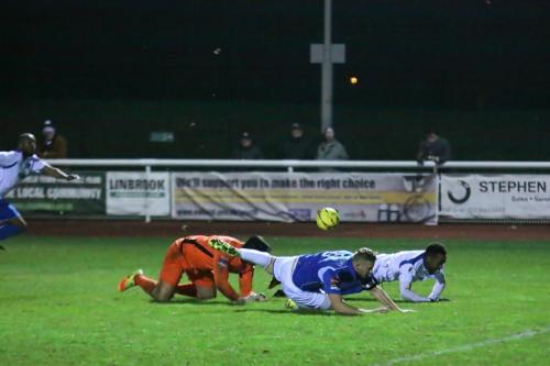 As Lowestofts keeper Jamie Waite and Ross Jarvis and Enfields Bobby Devyne struggle to their feet Ricky Gabriel (far L) runs to the loose ball