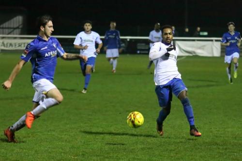 Lowestofts Travis Cole (L) maoves across to clear  from Bobby Devyne