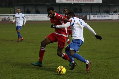 Enfields Bobby Devyne (R) runs at Marc Okoye