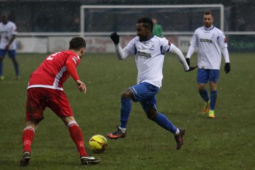 Enfields Bobby Devyne runs at Simon Cooper during a brief snow shower