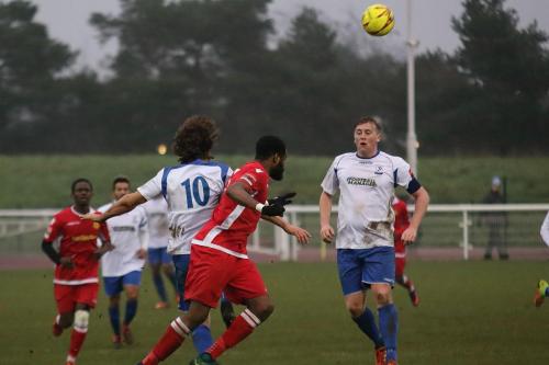 Mersthams Marc Okoye (red) heads clear under challenge from Harry Ottaway