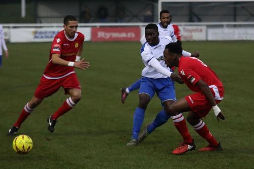 Percy Kiangebeni plays the ball between Mersthams Tutu Henriques (L) and Kristian Campbell