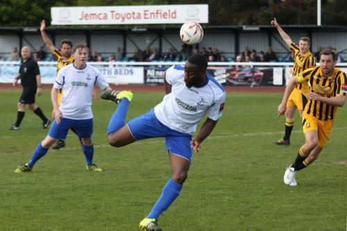 Enfields Harold Joseph backheels the ball towards Mark Kirby (L)