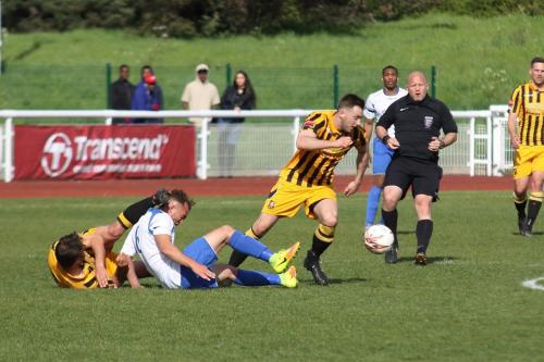 Enfields Scott Shulton receives a boot to the head from Folkestones Jordan Wright as Miles Cornwell comes away with the ball