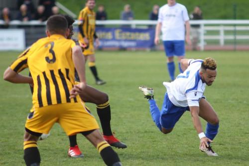 Enfields Tyler Campbell (R) loses his balance after a tackle by Nathan Fergusn (red boots)