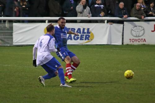 Needhams Luke Ingram (blue) clears from Billy Crook