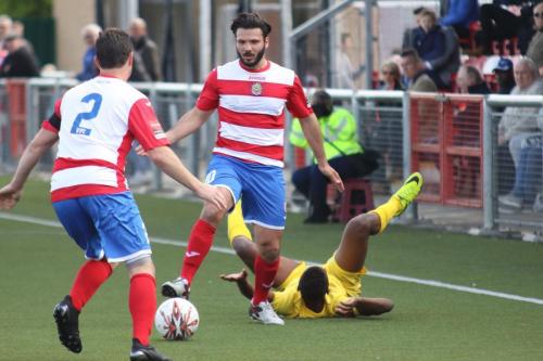 Enfields Karl Oliyide is brought down by Mario Noto (centre)