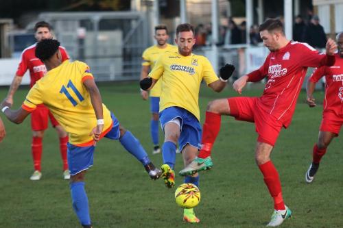 Enfields Dernell Wynter (L) and Scott Shulton and Harrows Josh Webb challenge for a loose ball