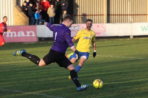Harrow keeper Luke Williams clears from Scott Shulton