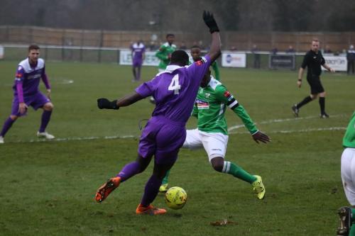 Enfields Percy Kiangebeni (purple) runs at Paul Semakula