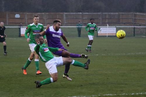 Enfields Tyler Campbell (purple), challenged by Danny Murphy,  just fails to lift the ball over the keeper