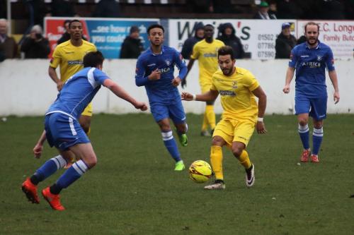 Enfields Tyler Campbell (yellow) plays the ball forward as Travis Cole (L) covers