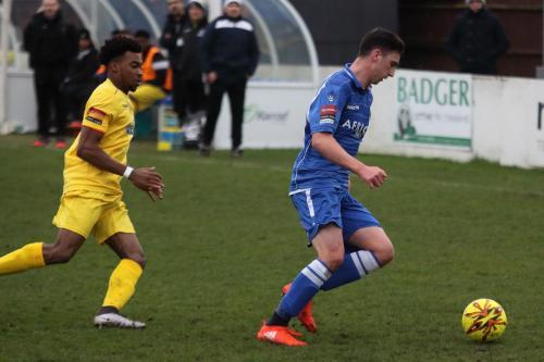 Lowestofts Travis Cole (blue) challenged by Dernell Wynter