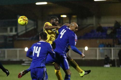Enfields Harold Joseph (yellow) challenges Steve Sutherland