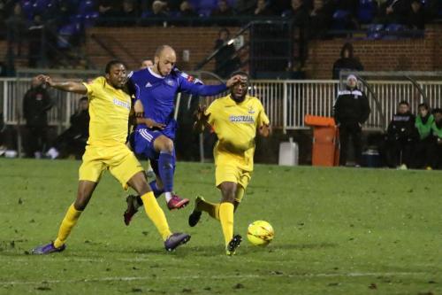 Enfields Ricky Gabriel (L) reaches the ball ahead of Lloyd Macklin and plays it back to his keeper Nathan McDonald, whose error allows Macklin to open the scoring