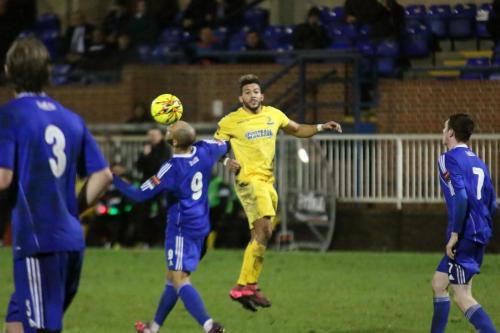 Enfields Tyler Campbell (yellow) heads the ball over Lloyd Macklin
