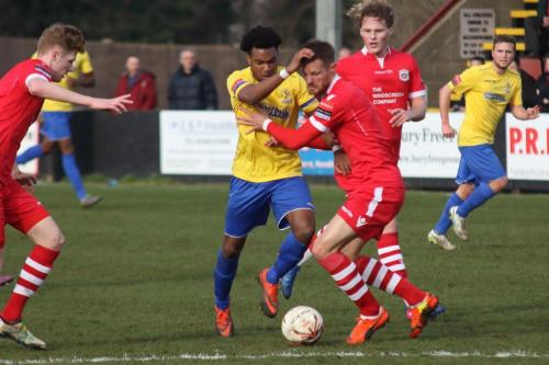 Enfields Dernell Wynter (yellow) tries to get past Ian Miller