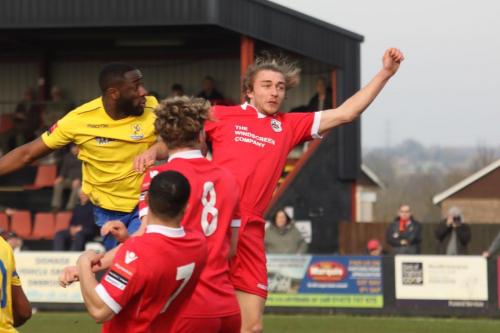 Harold Joseph  (yellow) beats Keiran Morphew to put Enfield 2-0 ahead