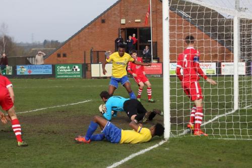 Needham keeper Danny Gay dives on the ball after a goalmouth scramble