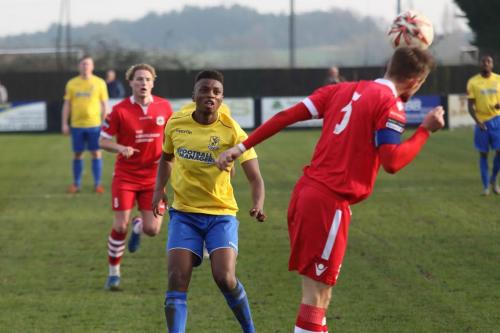 Needhams Ian Miller (R) clears from Karl Oliyide