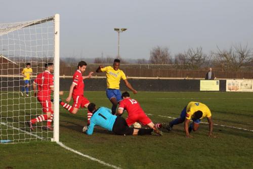 Needhams Joe Whight (15) has the ball stuck between his legs  The referee failed to spot that he then cleared it with his hand