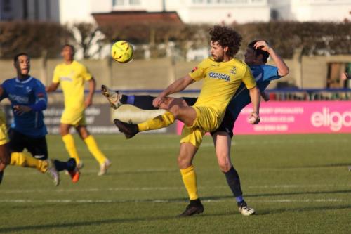 Enfields Harry Ottaway (yellow) and Wingates Sean Cronin stretch for the ball