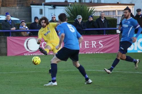 Enfields Harry Ottaway (yellow) curls the ball across the penalty area