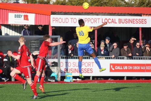 Enfields Karl Oliyide (yellow) wins a header