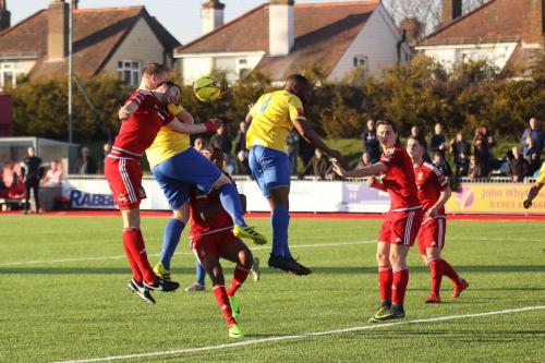 Enfields Mark Kirby (yellow, L) gets a header on target