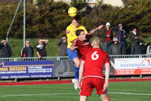 Enfields Mickey Parcell (yellow) beats Sam Rents to get a header on target