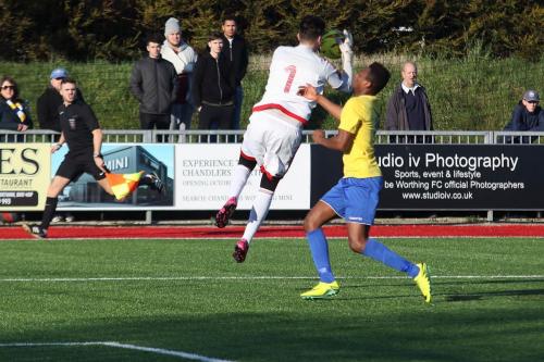 Worthing keeper Kieron Thorp reaches the ball ahead of Karl Oliyide
