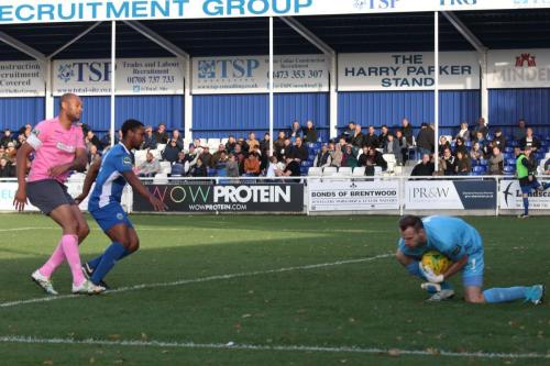 Billericay keeper Alan Julian makes a comfortable save as Leo Chambers and Enfields Simon Thomas (L) look for a mistake