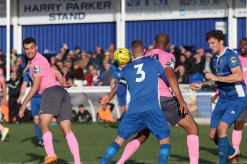 Enfields Taylor McKenzie (L) hits Paul Konchesky (3) with his header