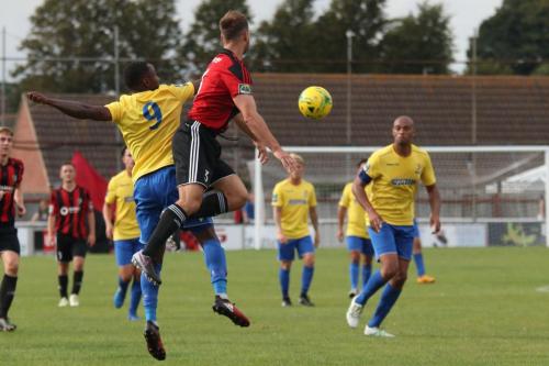Brightlingseas Jake Gould (red) beats Ryan Blake to a header