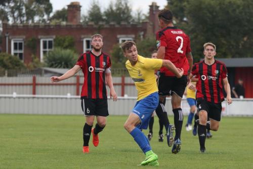 Brightlingseas Ricky Griggs (2) heads clear from Ben Ward-Cochrane
